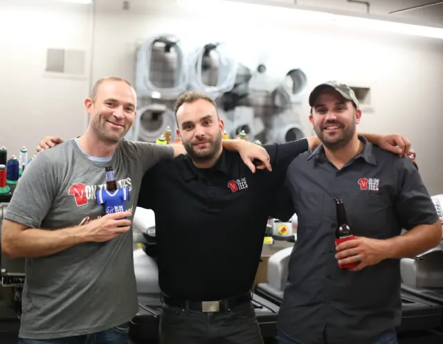 OnTime Promo & Apparel team members wearing OnTime logo shirts in the print shop